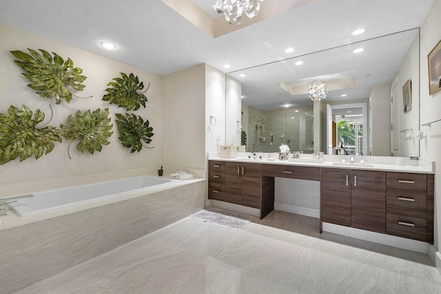 bathroom featuring tile floors, tiled bath, a chandelier, and dual bowl vanity