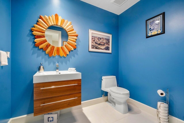 bathroom with tile flooring, toilet, and vanity