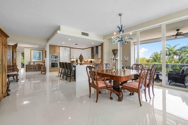 tiled dining space with sink and ceiling fan with notable chandelier