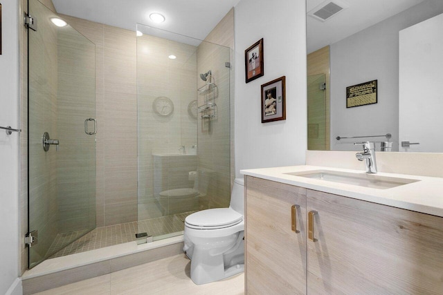 bathroom featuring a shower with shower door, toilet, and vanity