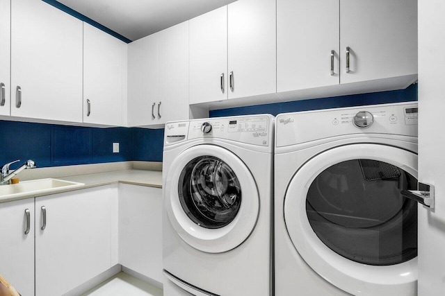 laundry area with sink, independent washer and dryer, and cabinets