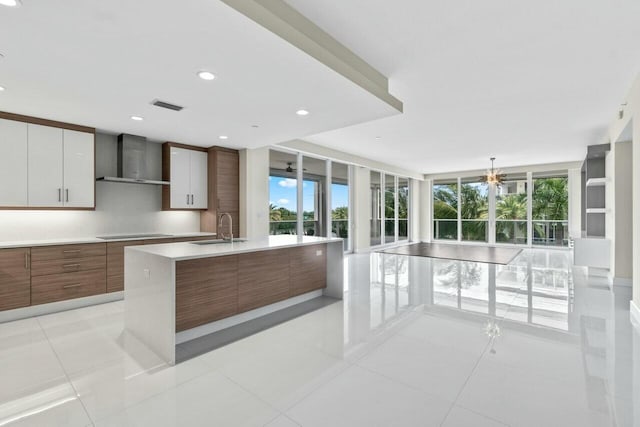 2720 Donald Ross Rd Unit 301, Palm Beach Gardens, FL 33410 - kitchen with wall chimney range hood, a wall of windows, light countertops, and modern cabinets