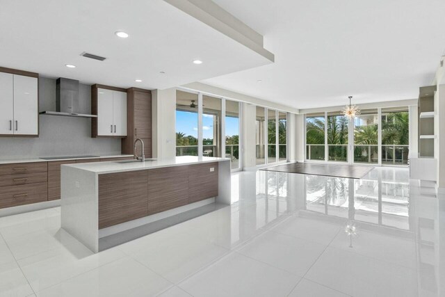 2720 Donald Ross Rd Unit 301, Palm Beach Gardens, FL 33410 - kitchen with light countertops, wall chimney exhaust hood, a sink, and a healthy amount of sunlight
