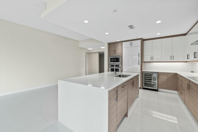 2720 Donald Ross Rd Unit 301, Palm Beach Gardens, FL 33410 - kitchen featuring visible vents, modern cabinets, appliances with stainless steel finishes, beverage cooler, and a sink