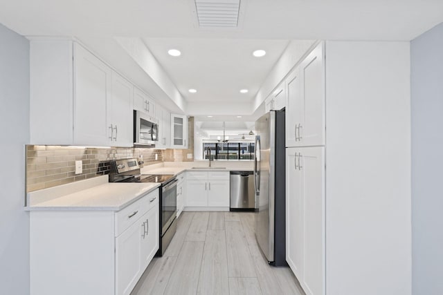 kitchen featuring backsplash, stainless steel appliances, white cabinets, and sink