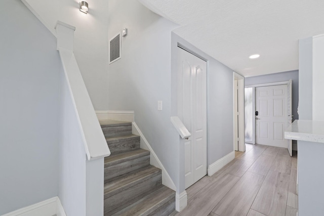 stairway with light wood-type flooring