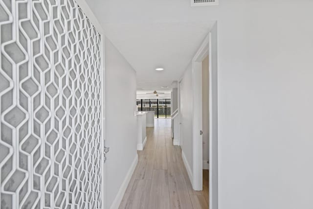 hallway with light hardwood / wood-style flooring