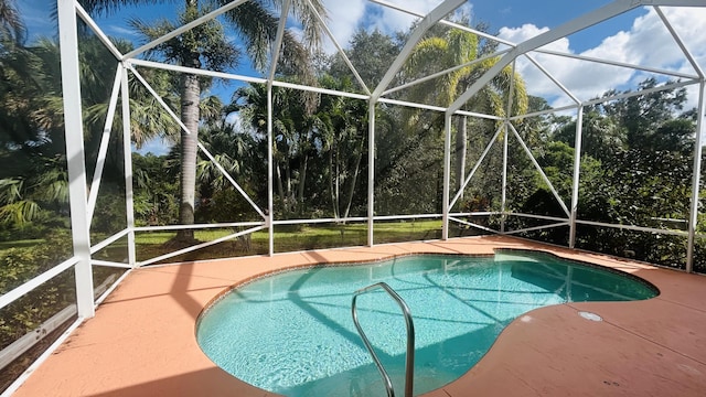 pool featuring glass enclosure and a patio