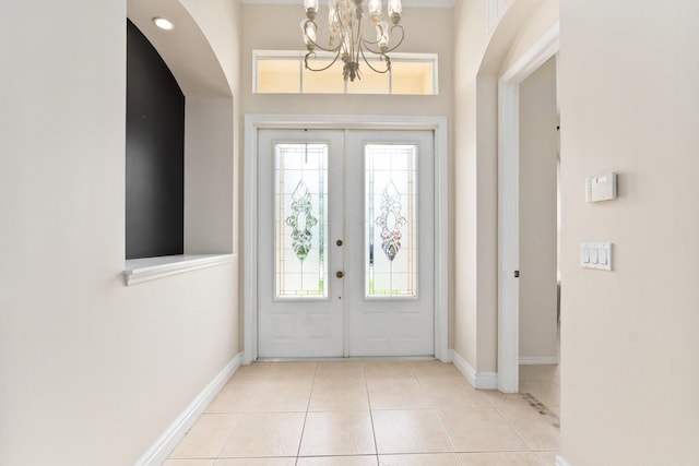 entryway featuring tile patterned flooring, baseboards, a notable chandelier, and french doors