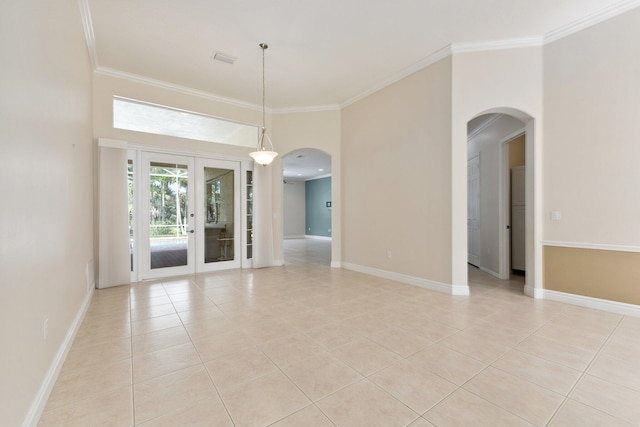 unfurnished room featuring light tile patterned floors, baseboards, ornamental molding, and arched walkways