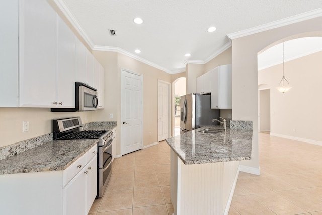 kitchen featuring crown molding, light tile patterned floors, appliances with stainless steel finishes, a sink, and a peninsula