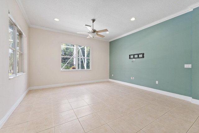 spare room featuring light tile patterned floors, plenty of natural light, baseboards, and crown molding