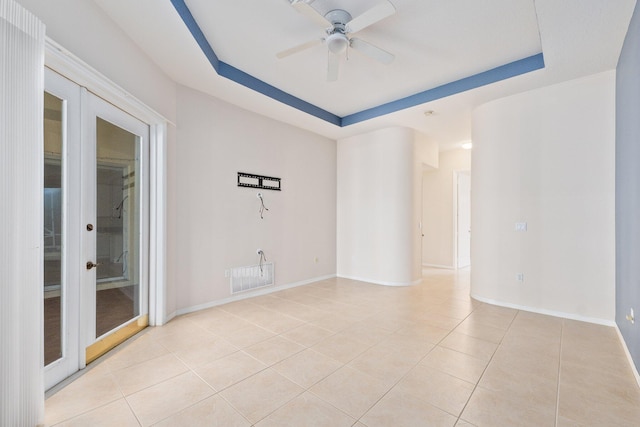 unfurnished room featuring light tile patterned floors, visible vents, baseboards, french doors, and a raised ceiling