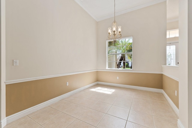 tiled spare room featuring a chandelier, ornamental molding, and baseboards