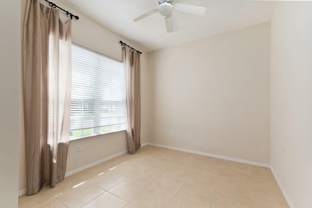 spare room featuring ceiling fan, baseboards, and light tile patterned floors