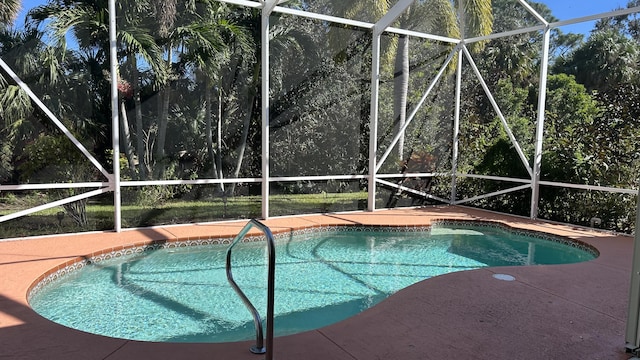 outdoor pool with a lanai and a patio area