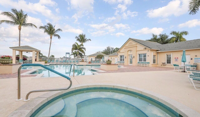 pool featuring a gazebo, a patio area, and a hot tub