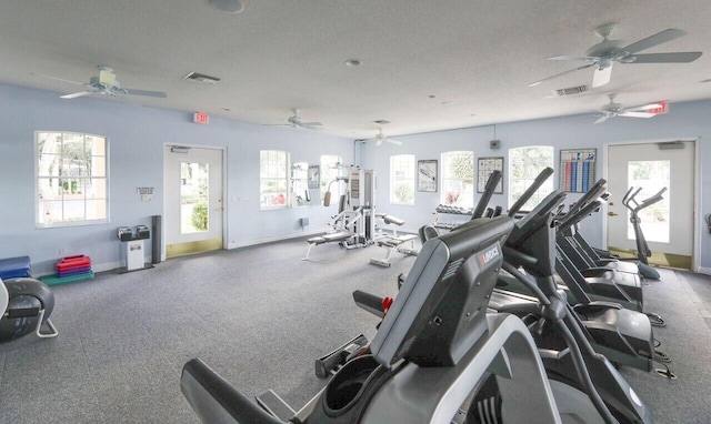 workout area with a textured ceiling, visible vents, and baseboards