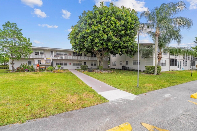 view of front facade with a front lawn and a balcony