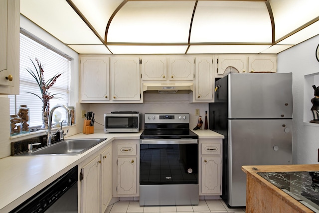 kitchen with light tile patterned floors, appliances with stainless steel finishes, under cabinet range hood, light countertops, and a sink
