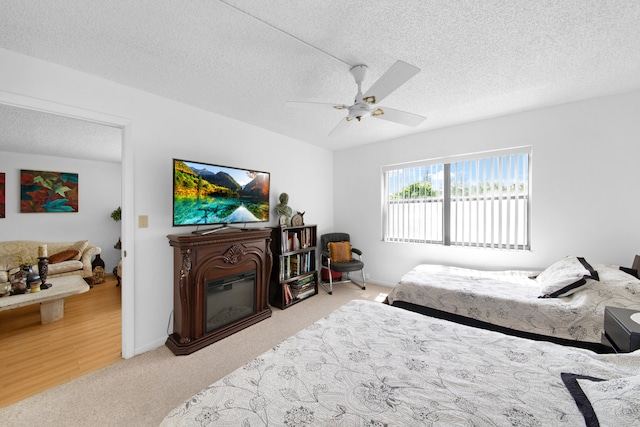 carpeted bedroom featuring a textured ceiling and ceiling fan