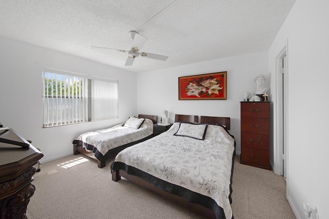 carpeted bedroom featuring baseboards, a textured ceiling, and a ceiling fan
