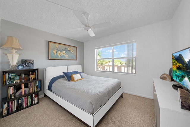 bedroom featuring ceiling fan, light carpet, and a textured ceiling