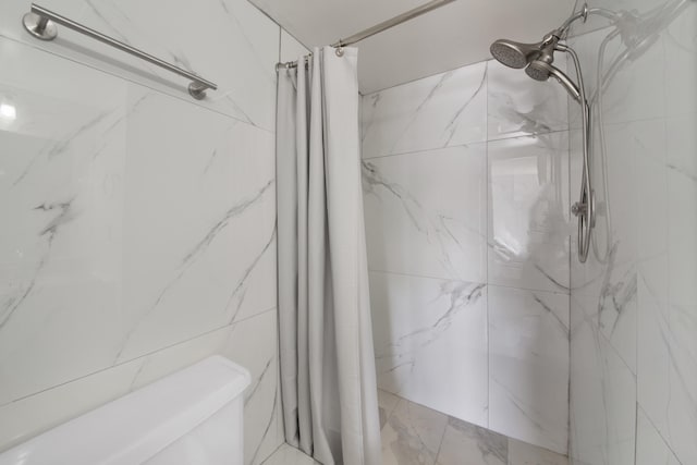 bathroom with a shower with shower curtain and toilet