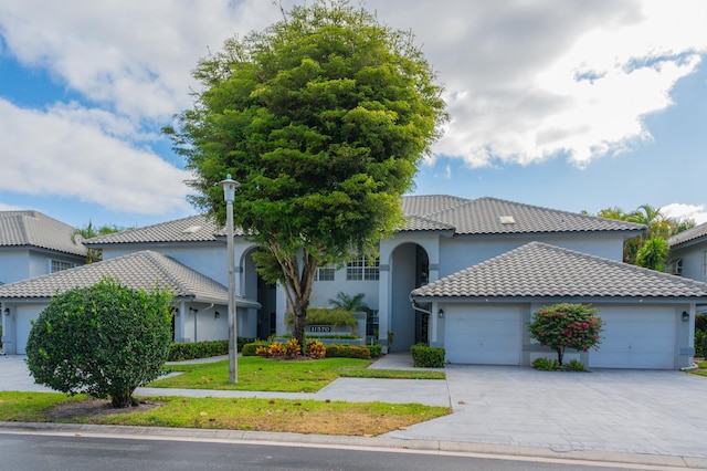 mediterranean / spanish home with a garage and a front lawn