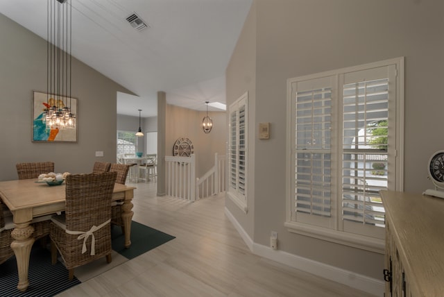 dining room with lofted ceiling and light wood-type flooring