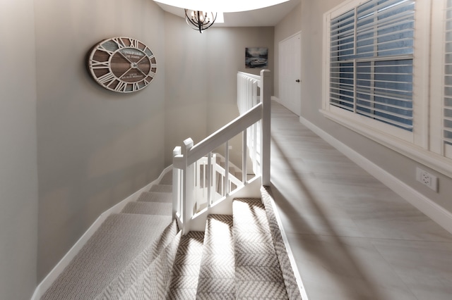 staircase with a chandelier