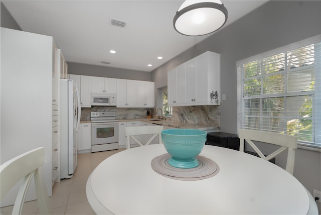 kitchen featuring white cabinets, white appliances, light tile flooring, backsplash, and sink