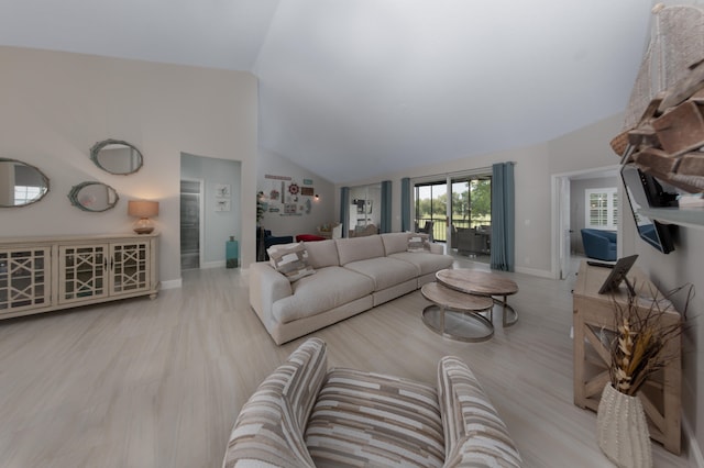 living room with high vaulted ceiling and light wood-type flooring