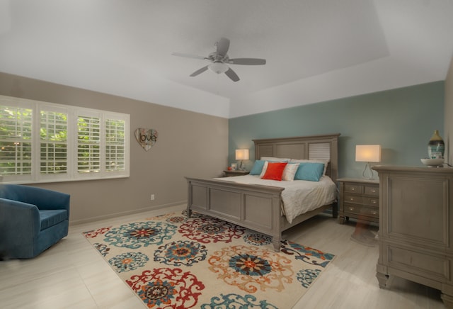 bedroom with ceiling fan and a raised ceiling