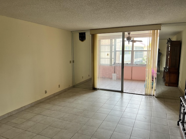 tiled empty room featuring a textured ceiling