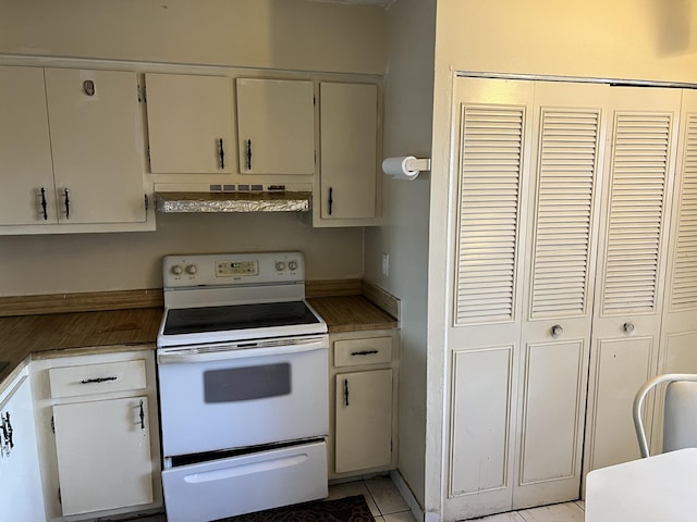 kitchen with white electric stove, light tile floors, wall chimney exhaust hood, and white cabinetry