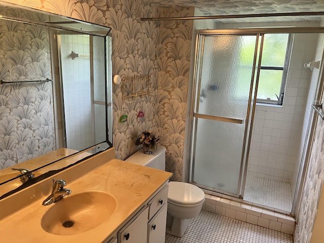 bathroom featuring tile floors, vanity, toilet, and a shower with shower door