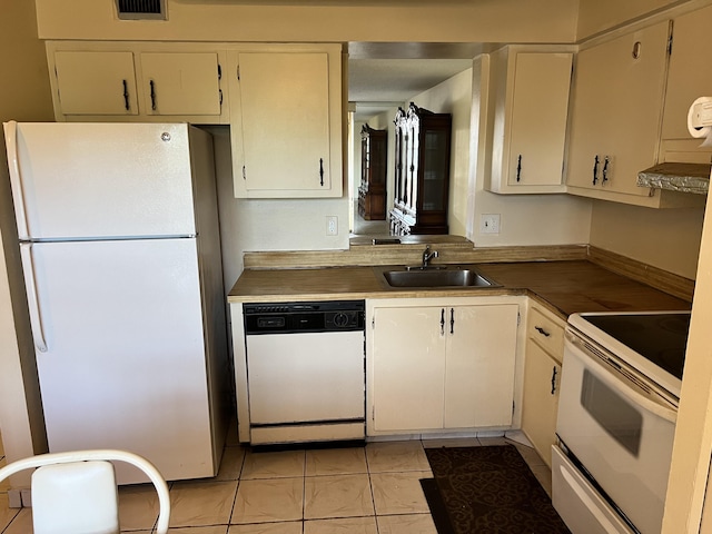 kitchen with white appliances, sink, light tile floors, and white cabinetry