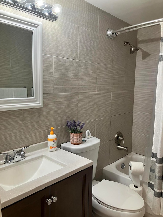 full bathroom with tile walls, vanity, toilet, and shower / bath combo with shower curtain