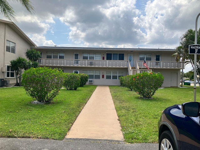 view of property with a front lawn and central air condition unit