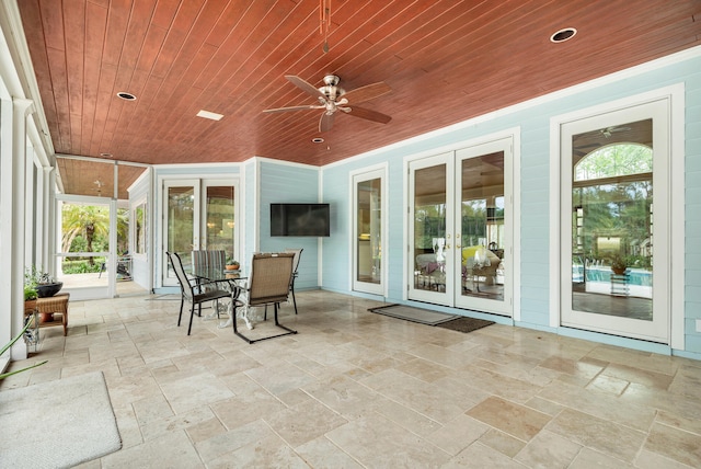 sunroom / solarium featuring french doors, plenty of natural light, ceiling fan, and wooden ceiling