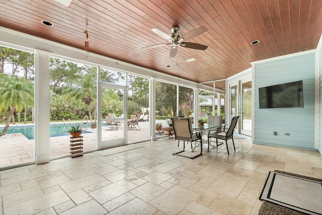 unfurnished sunroom with ceiling fan and wooden ceiling