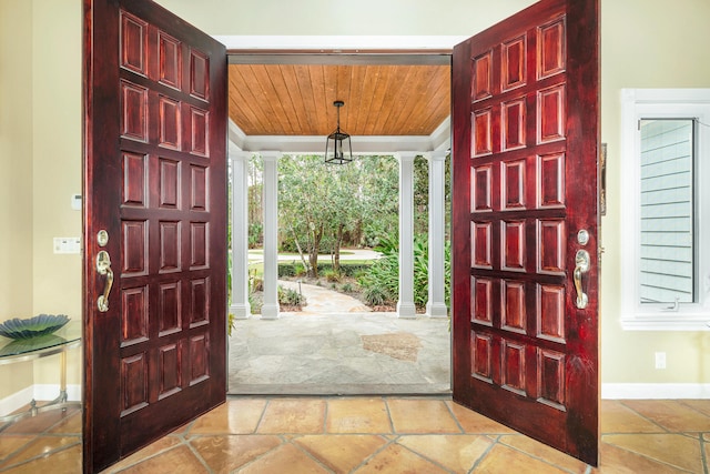 tiled entryway featuring wooden ceiling and ornate columns