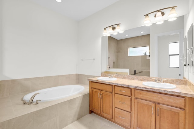 bathroom with tile patterned flooring, independent shower and bath, and vanity