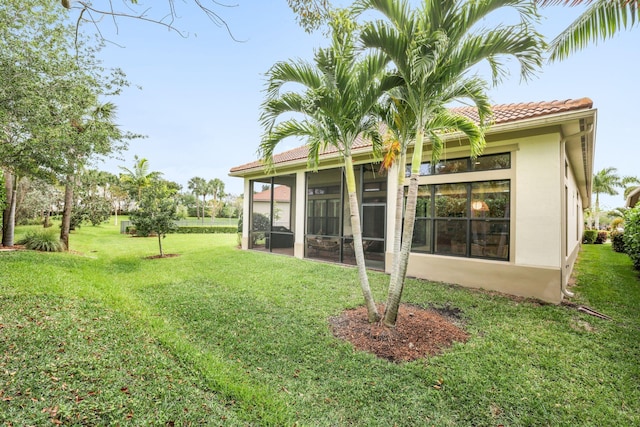 rear view of house with a sunroom and a yard