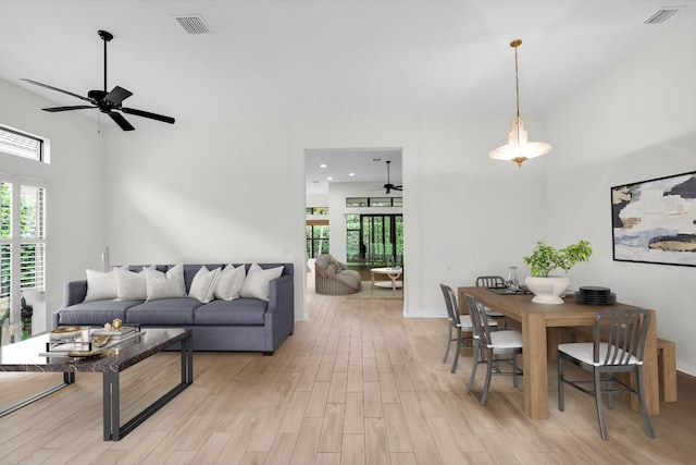 living room featuring light hardwood / wood-style floors, ceiling fan, and a wealth of natural light