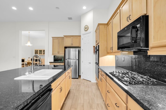 kitchen featuring sink, decorative light fixtures, black appliances, light brown cabinetry, and decorative backsplash