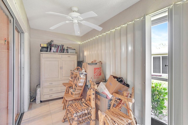 sitting room with ceiling fan and light tile floors