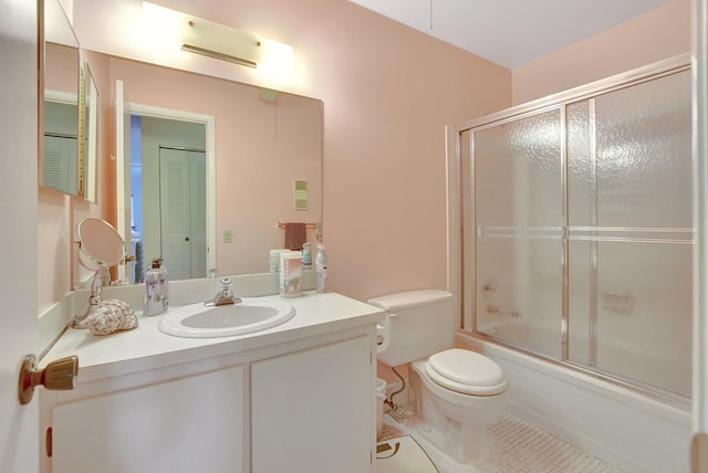 full bathroom with tile flooring, vanity, toilet, and shower / bath combination with glass door