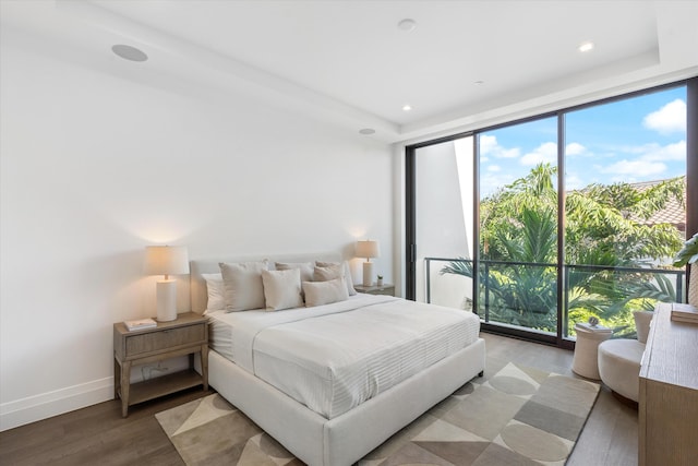 bedroom featuring wood-type flooring and expansive windows